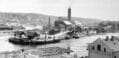 TELEMARKSBRYGGA: På Smieøya der fløtermonumentet står, var det brygge for telemarksbåtene fra 1861 til 1900. Her var det livlig trafikk og et laste- og lossested for varer og folk. Bildet er fra før 1900 siden Hjellebrygga ikke er påbegynt