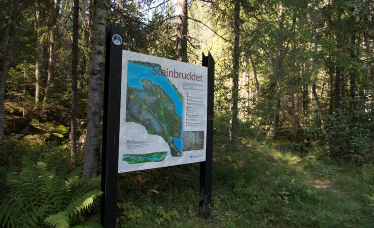 SKILT: Hvis en følger stien fra toppen i Vrangfoss sluser til steinbruddet, finner en dette skiltet som informerer om bruddet og arbeidet der.